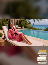 Load image into Gallery viewer, Woman reclining on a poolside lounger in the Blush Hollow silk peignoir, ombré cuff and hem style with black trim and tie