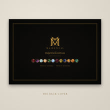 Load image into Gallery viewer, Black and gold back cover of the calendar with the Majestical owl logo and twelve stone medallions