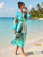 Load image into Gallery viewer, Woman walking along the shoreline in the Ocean Muse silk peignoir, classic style with ivory trim and tie

